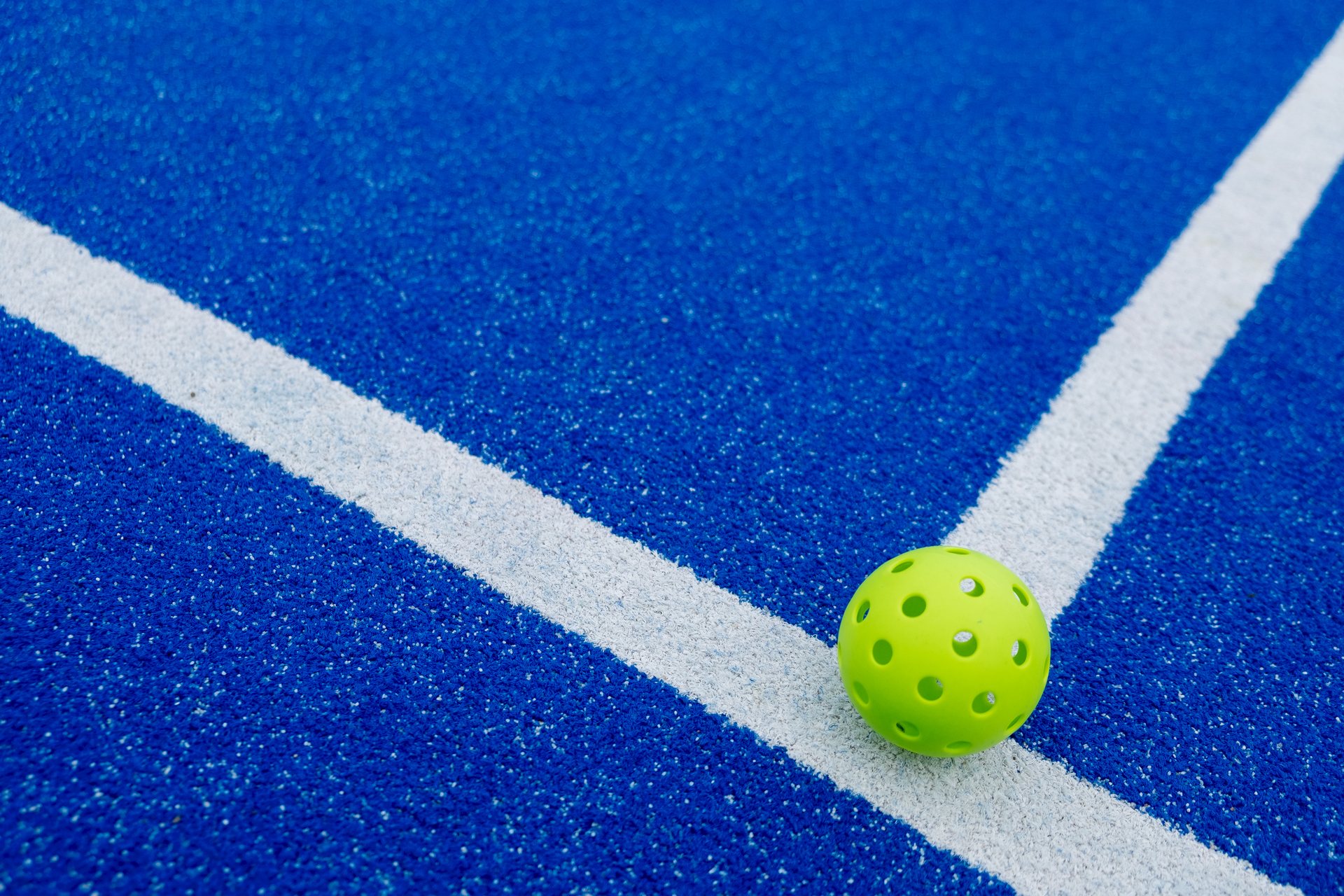 Bola de pickleball sobre la línea de una pista